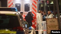 Forensic experts are seen outside a bar after a shooting in Hanau near Frankfurt, Germany, Feb. 20, 2020. 