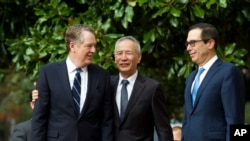 Chinese Vice Premier Liu He accompanied by U.S. Trade Representative Robert Lighthizer, left, and Treasury Secretary Steven Mnuchin, greets the media before a minister-level trade meeting in Washington, Thursday, Oct. 10, 2019. 