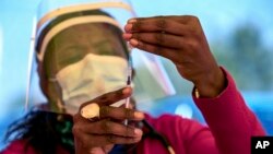 In this May 25, 2021, file photo, a health worker prepares a dose of the Pfizer coronavirus vaccine at the Orange Farm Clinic near Johannesburg. In the global race to vaccinate people against COVID-19, Africa is tragically at the back of the pack. (AP Pho