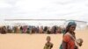 A woman walks with her children to a transit center in the Dolo Ado refugee camp in southern Ethiopia, July 19, 2011.