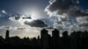 Buildings are silhouetted as clouds drift past the sun in Shanghai on Sept. 17, 2024. 