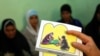 FILE - A counselor holds up cards used to educate women about female genital mutilation (FGM).