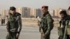 FILE - Members of the Kurdish-led Syrian Democratic Forces stand along a street, after rebels seized the capital and ousted Syria's Bashar al-Assad, in Hasakah, Syria, Dec. 11, 2024.