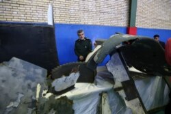 FILE - Head of the Revolutionary Guard's aerospace division Gen. Amir Ali Hajizadeh looks at debris from what the division describes as the U.S. drone which was shot down in Tehran, Iran, June 21, 2019.