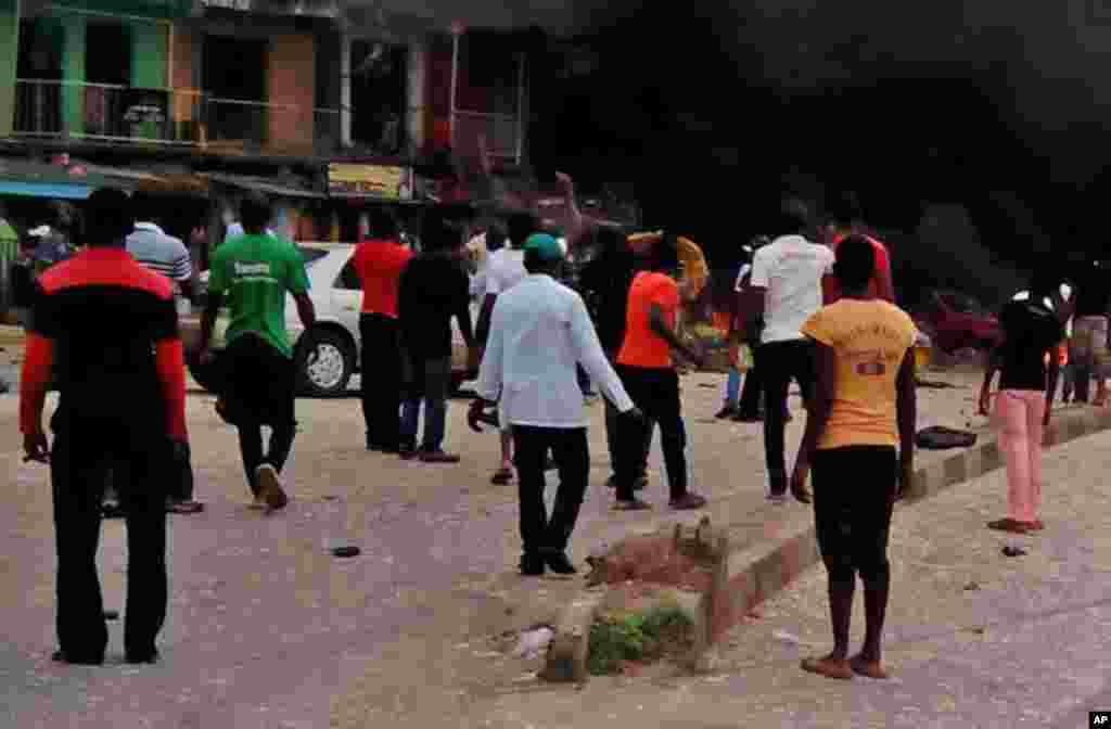 Mutane na kallon wajenda Bom ya fashe a birnin Jos, dake Jihar Filato.