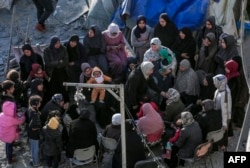 Warga Palestina duduk di tengah tenda dan tempat penampungan sementara yang hancur akibat serangan Israel di Deir el-Balah di Gaza tengah pada 2 Maret 2024. (Foto: AFP)