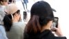 Beberapa remaja di Melbourne, Australia sedang menggunakan ponsel mereka di tengah rencana pemerintah negara itu untuk melarang anak-anak di bawah usia 16 tahun untuk menggunakan media sosial, Kamis, 28 November 2024. (Foto: William West/AFP)