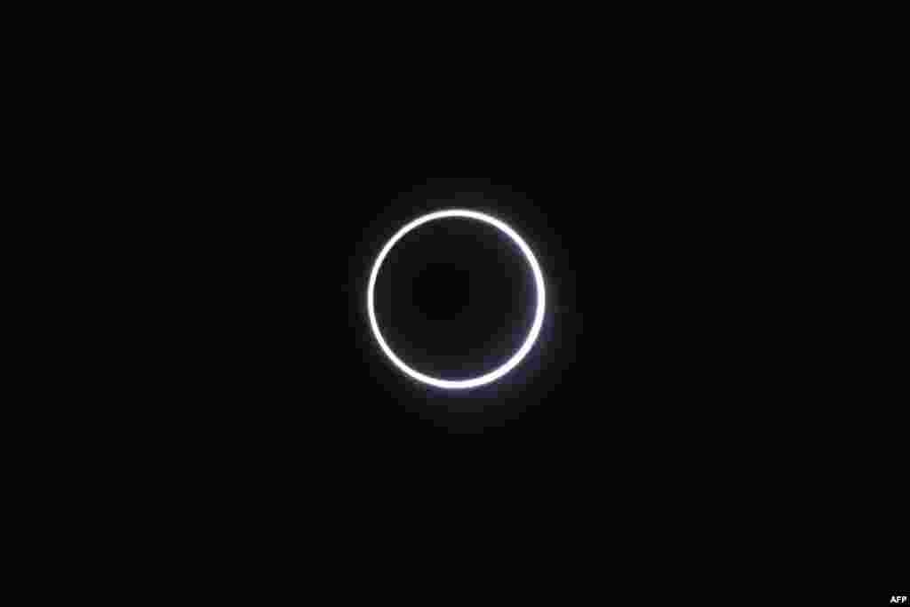 The moon covering the sun, leaving a ring of fire effect around the moon, during an annular solar eclipse in Saint-Louis, on the Indian Ocean island of La Reunion.