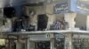 FILE - Residents sit on the balcony of a damaged building in Aleppo's al-Shaar neighborhood, Syria, Aug.1, 2015.