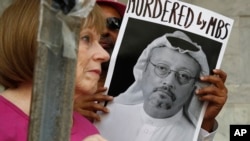 Para peserta unjuk rasa menunjukan poster dalam demo memprotes hilangnya wartawan Jamal Khashoggi di depan Kedutaan Besar Arab Saudi di Washington, 10 Oktober 2018. Khashoggi akhirnya diketahui tewas dibunuh di Konsulat Arab Saudi di Istanbul, Turki.