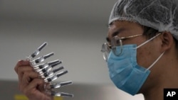 Seorang karyawan memeriksa jarum suntik Vaksin SARS CoV-2 untuk Covid-19 yang diproduksi oleh SinoVac di pabriknya di Beijing, 24 September 2020. (Foto: Reuters)
