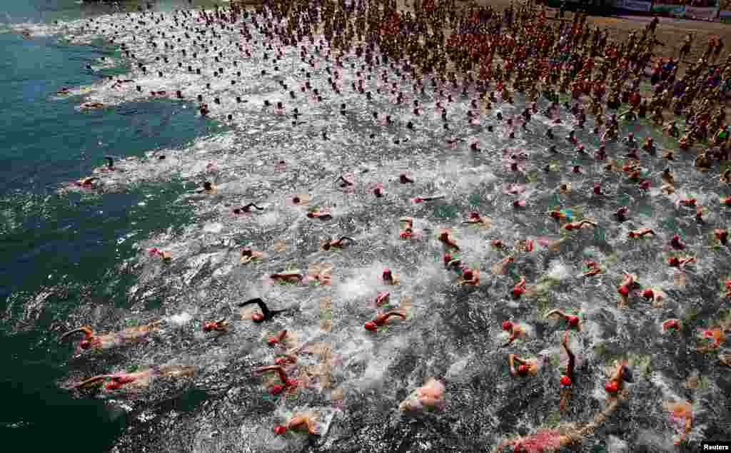 People participate in the annual public Lake Zurich crossing swimming event in Zurich, Switzerland.