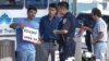 An organizer with Coalition for Humane Immigrant Rights of Los Angeles, is questioned by a federal guard during group's rally in response to ruling by U.S. Supreme Court on Arizona's immigrationin Los Angeles, June 25, 2012.