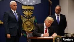 U.S. President Donald Trump signs a revised executive order for a U.S. travel ban on Monday, leaving Iraq off the list of targeted countries, at the Pentagon in Washington.