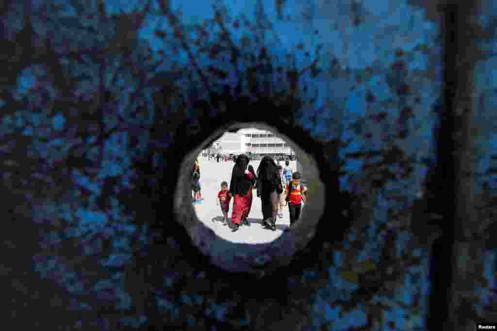 Refugee schoolchildren walk with their mothers on the first day of the new school year at one of the UNRWA schools at a Palestinian refugee camp al Wehdat, in Amman, Jordan.