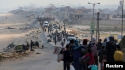 Sejumlah warga Palestina berusaha kembali ke rumah mereka di utara Gaza dengan berjalan melewati pos pemeriksaan Israel di wilayah Gaza tengah pada 15 April 2024. (Foto: Reuters/Ramadan Abed)