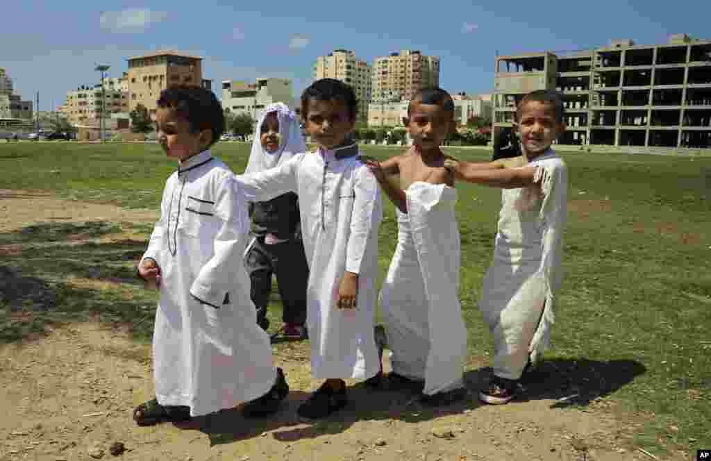Palestinian students dressed like Muslim pilgrims walk together at the main square in Gaza City, during a school lesson about the hajj pilgrimage to Mecca, Saudi Arabia.