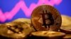 FILE - A representation of virtual currency bitcoin is seen in front of a stock graph in this illustration taken Jan. 8, 2021.