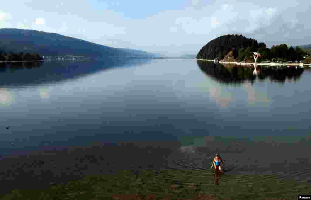 Fabienne Rochat-Jaeggi comes out of the Joux lake after her morning swim on a warm autumn day in Le Pont, Switzerland.
