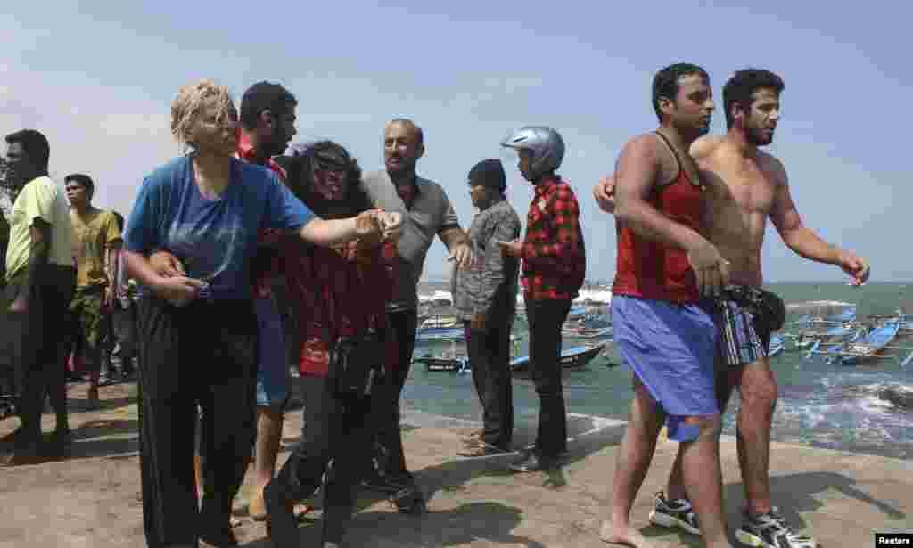 Suspected asylum seekers that were on a boat that capsized July 23 after hitting a reef, arrive at Jayanti beach, West Java province, Indonesia, July 24, 2013. 