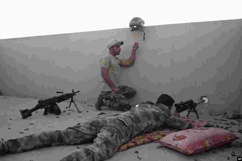 An Iraqi special forces soldier holds up a helmet as a decoy while a sniper prepares to fire on Islamic State positions in Gogjali, on the eastern edges of Mosul.