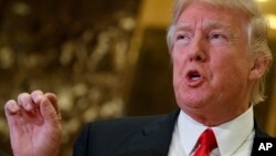 FILE - President-elect Donald Trump speaks with reporters in the lobby of Trump Tower in New York, Jan. 13, 2017. 