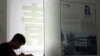 In this June 26, 2014 photo, 16-year-old Zhang Kaisheng studies near advertisements for oversea schools at Focus Education, a tutoring and consulting agency in Beijing.