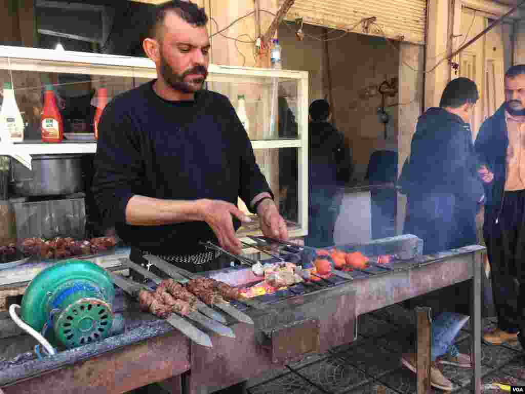 Wani namiji a kasuwar Mosul na dafa naman kabobs, a Iraqi ranar 23 ga watan Fabrairu, 2017 (K. Omar/VOA) 