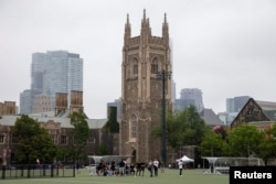 FILE - People take a break from playing sports on the grounds of the University of Toronto, Sept. 9, 2020.