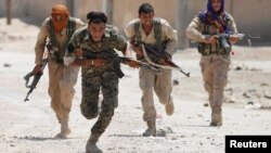 Milisi Kurdi (YPG) berlari dalam pertempuran melawan militan ISIS di Raqqa, Suriah utara (foto: ilustrasi).