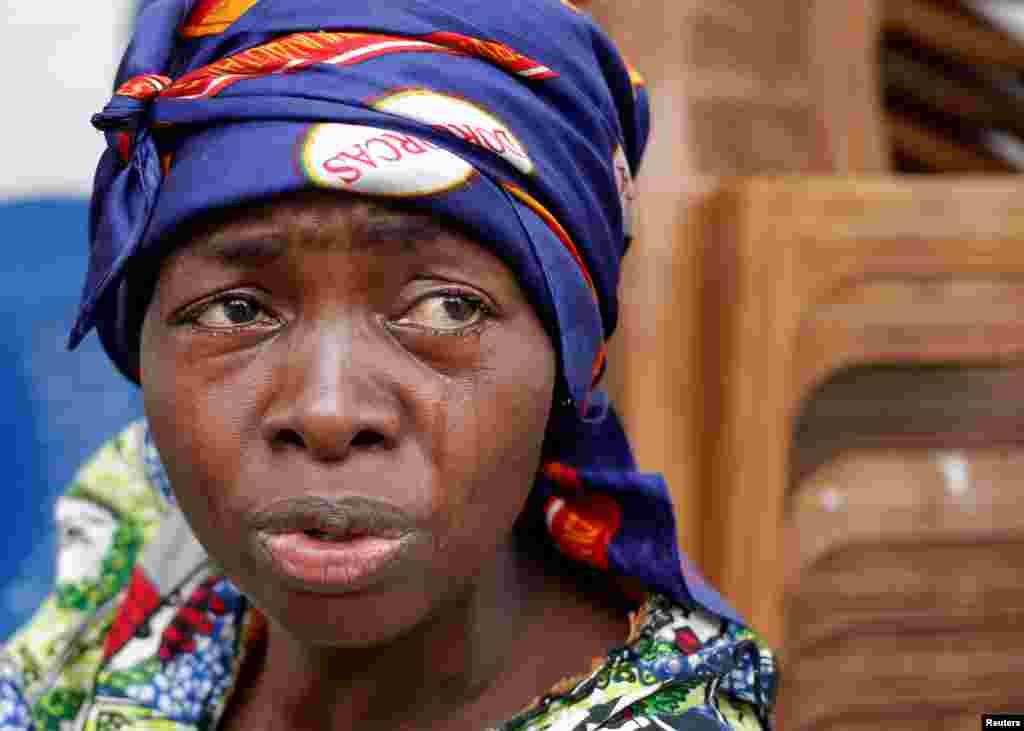 A woman cries for her husband, who according to witnesses was killed when security forces burned down the headquarters of the main opposition party Union for Democracy and Social Progress (UDPS), in front of a UDPS office in Kinshasa, Democratic Republic of Congo.