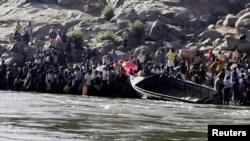 Orang-orang Etiopia yang melarikan diri dari konflik di Tigray bersiap menyeberang Sungai Setit di perbatasan Sudan-Etiopia di Desa Hamdait, di negara bagian Kassala, Sabtu, 14 November 2020. 