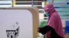 Seorang perempuan memberikan suaranya saat pemilihan negara bagian di sebuah pusat pemungutan suara di Malaka, Malaysia, Sabtu, 20 November 2021. (Foto: AP)