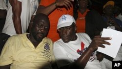 Presidential candidate Winston Tubman (R) sits next to his running-mate George Weah of the Congress for Democratic Change (CDC) during the party's rally at a stadium in Monrovia (file photo)