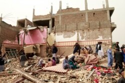 Locals inspect the site of a car bomb attack in Herat province, west of Kabul, Afghanistan, March 13, 2021.