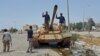 FILE - Members of Libyan pro-government forces on a tank in Benghazi, May 21, 2015
