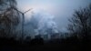 Uap air membubung dari menara-menara pendingin PLTU Jaenschwalde milik Lausitz Energie Bergbau AG, yang tak jauh dari turbin angin di Jaenschwalde, Jerman, 24 Januari 2019.