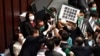 香港立法会泛民主派议员在内务委员会的一个会议期间举牌抗议中国人大制定香港国安法，他们被保安阻拦。（2020年5月22日）