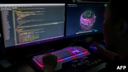 Layar monitor kelompok peretas Red Hacker Alliance sedang menampilkan status serangan siber global dari kantor mereka di Dongguan, Provinsi Guangdong, China, 4 Agustus 2020. (Foto: Nicolas Asfouri/AFP)