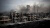 FILE - Smoke is seen rising over Saif Al Dawla district, in Aleppo, Syria.