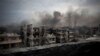 FILE - Smoke is seen rising over Saif Al Dawla district, in Aleppo, Syria.