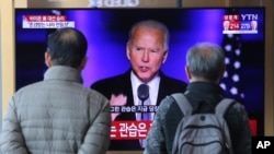People watch a TV screen showing the broadcast of President-elect Joe Biden speaking, at the Seoul Railway Station in Seoul, South Korea, Sunday, Nov. 8, 2020. (AP Photo/Ahn Young-joon)
