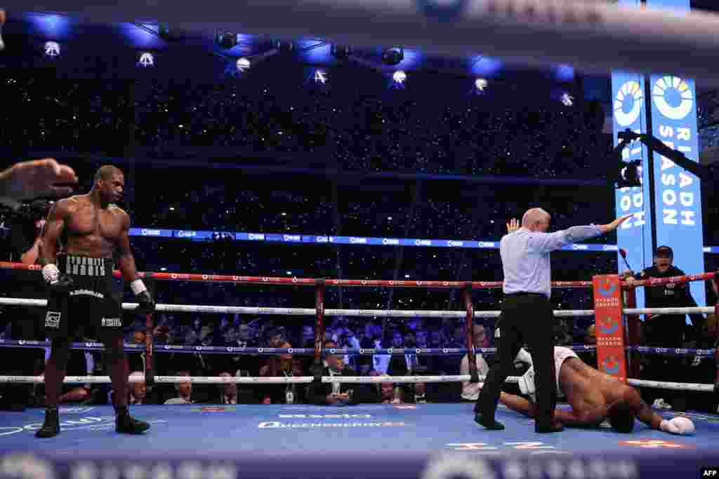 Moyi Grande-Bretagne Anthony Joshua akweyi na makofi ya moyi Grande-Bretagne mosusu Daniel Dubois na bitumba ya ba poids lourds ya nkamba ya molongo ya IBF na etando ya masano ya Wembley, Londres, Sanza 21 2024. (Photo by Adrian Dennis / AFP)
