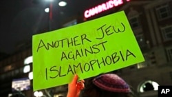 Sebuah poster bertuliskan "Warga Yahudi yang menentang Islamofobia" diacungkan oleh seorang demonstran dalam aksi protes di dekat kampus Universitas Harvard pada 7 Maret 2017. (Foto: AP/Charles Krupa)