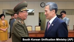 25일 파주시 판문점에서 남북한 고위급 접촉이 타결된 가운데, 남측 대표인 김관진 한국 국가안보실장(오른쪽)과 북측 대표인 황병서 북한 군 총정치국장이 악수하고 있다.