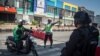 Petugas kepolisian menghentikan sepeda motor akibat pemberlakuan PPKM di Jawa dan Bali di tengah lonjakan kasus COVID-19, di Solo, Jawa Tengah, 8 Juli 2021. (Foto: Antara/Mohammad Ayudha via REUTERS)