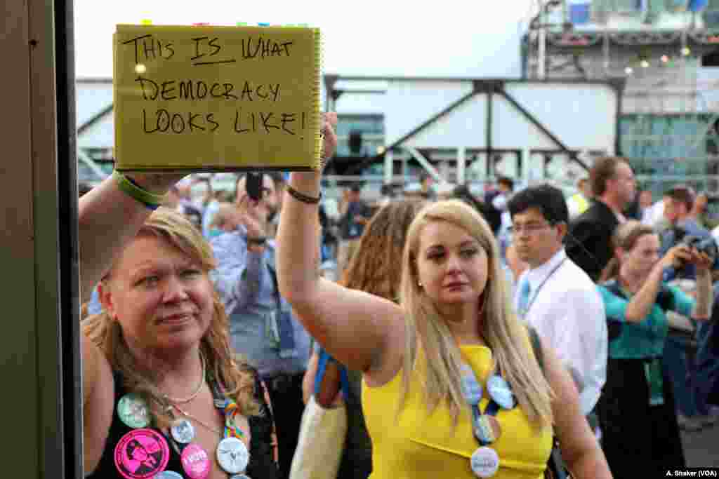 "This is what democracy looks like," reads a protest sign held by a Bernie Sanders supporter after Hillary Clinton was formally nominated at the Democratic National Convention in Philadelphia, July 26, 2016. (A. Shaker/VOA)