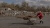 FILE - An elderly woman collects wood ahead of the winter in an area that was recently shelled in the village of Yasenove, south of the city of Pokrovsk, Donetsk region, on Oct. 8, 2024, amid the Russian invasion of Ukraine.