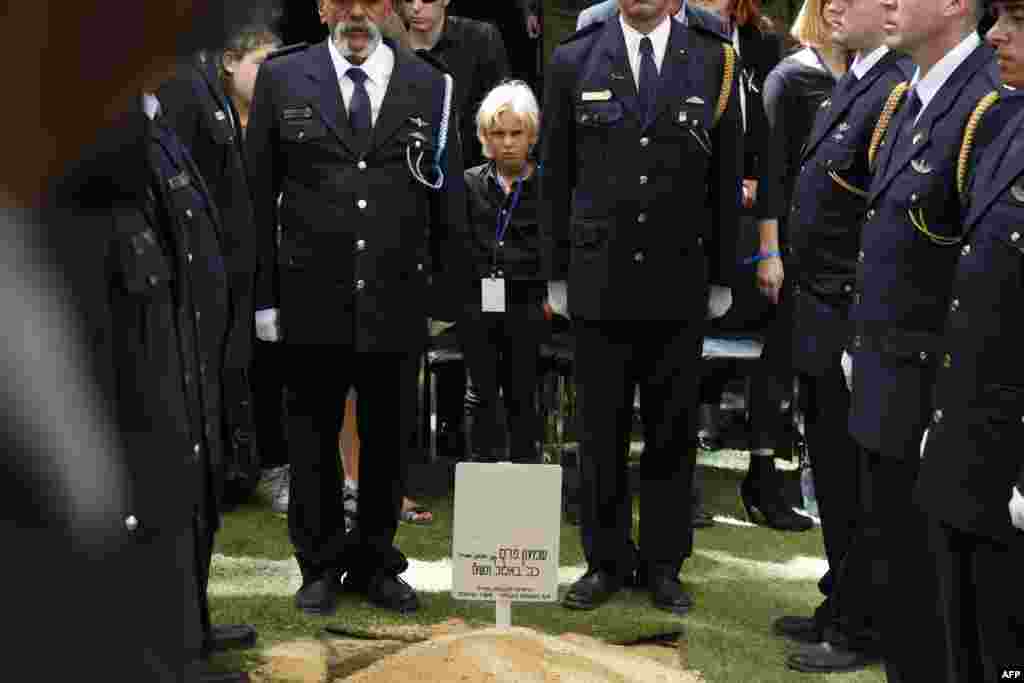 A grandson of former Israeli president Shimon Peres stands amid Knesset honor guards in front the grave of his grandfather during the burial ceremony at Mount Herzl Cemetery in Jerusalem. World leaders bid farewell to the ex-prime minister and Nobel Peace Prize winner as his funeral was held under massive security. 