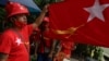 Pendukung partai Liga Nasional untuk Demokrasi (NLD) mengibarkan bendera Myamnar di Yangon pada 8 September 2020. Myanmar melewatkan KTT ASEAN setelah jenderal pemimpin dilarang menghadiri pertemuan itu. (Foto: AFP/Ye Aung Thu)